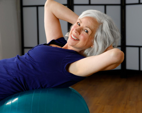 Femme senior souriante exercice périnée ballon