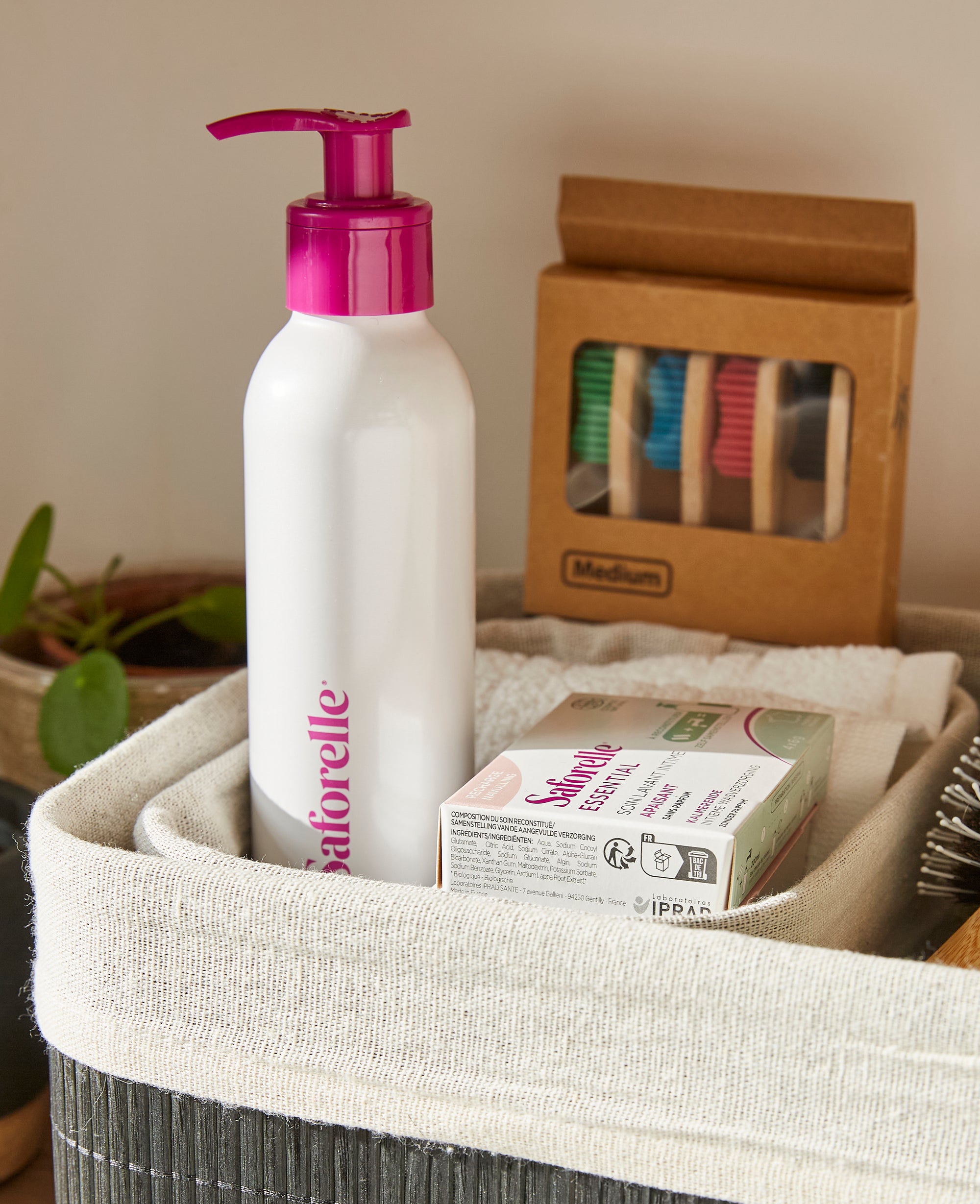 Flacon pompe Saforelle avec boîte de recharge soin lavant intime, apaisant 4 bâtonnets (4x6g) dans un panier, produit d’hygiène, confort intime